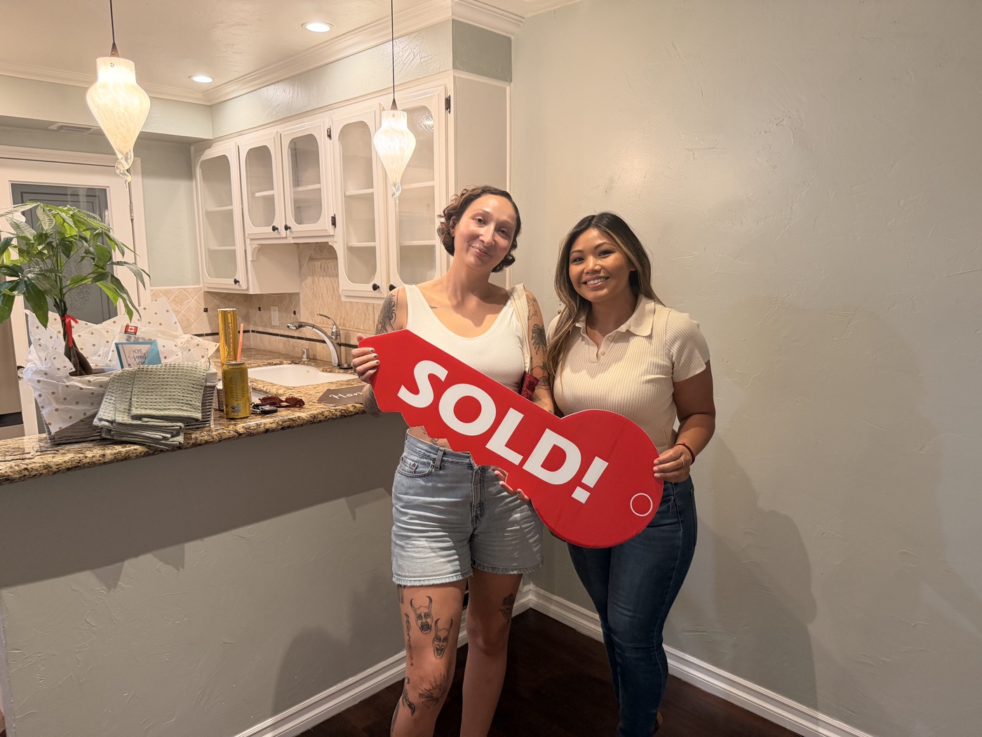 Client and Dianna smiling with a red sold key after closing